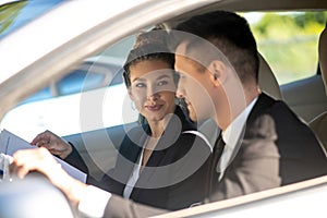 Young pretty woman and man in business suits in car
