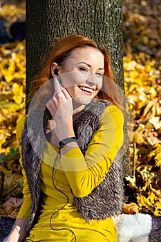 Young pretty woman in the park in autumn