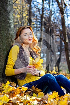 Young pretty woman in the park in autumn