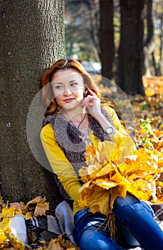 Young pretty woman in the park in autumn