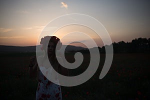 Young pretty woman in poppy fields