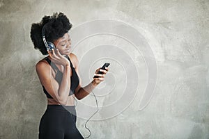 Young pretty woman. Portrait of african american girl in fitness clothes having a break after workout