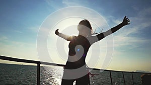 Young pretty woman poses on the yacht raises hands through the sun with lens flare effects. slow motion. 1920x1080
