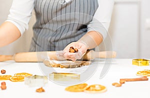 Young pretty woman prepares the dough and bakes gingerbread and cookies in the kitchen. Merry Christmas and Happy New