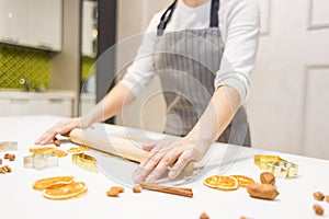 Young pretty woman prepares the dough and bakes gingerbread and cookies in the kitchen. Merry Christmas and Happy New