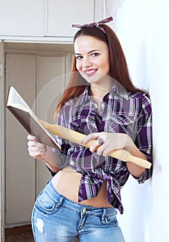 Young pretty woman reads cookbook for recipe