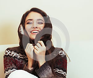 young pretty woman sitting in comfortable chair with coffee and blanket, winter season lifestyle people concept