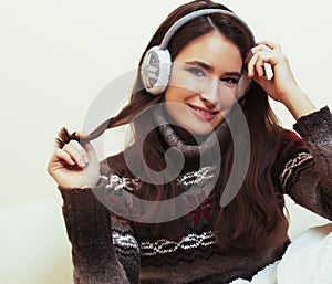 young pretty woman sitting in comfortable chair with coffee and blanket, winter season lifestyle people concept