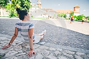 Young pretty woman sitting on the ground restting after long walk