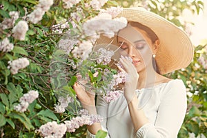 Young pretty woman smelling spring flowers outdoors