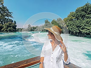 Young pretty woman is standing close up on the Manavgat waterfall background in Turkey