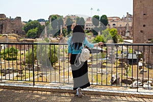 Young pretty woman in stylish fashion dress walking on street in Rome at sunny day. Travel and tourism concept