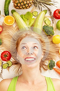 A young pretty woman surrounded by vegetables and fruits