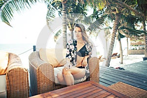 Young pretty woman at swimming pool relaxing in chair, fashion look in lingerie at hotel, lifestyle people concept