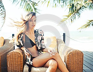 Young pretty woman at swimming pool relaxing in chair, fashion look in lingerie at hotel, lifestyle people concept