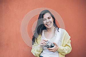 Young pretty woman taking picture with old camera