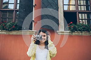 Young pretty woman taking picture with old camera