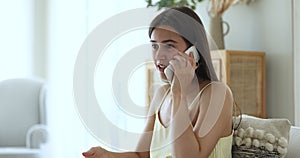 Young pretty woman talking on cell phone at home