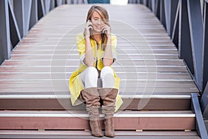 Young pretty woman talking at cellular phone on Bridge - woman having a conversation at smartphone