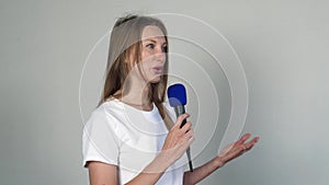 Young pretty woman talking with microphone.