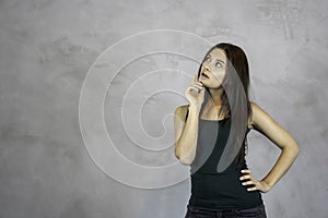 Young pretty woman thinking curious face questioning on grey background. copy space