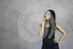 Young pretty woman thinking curious face questioning on grey background. copy space photo