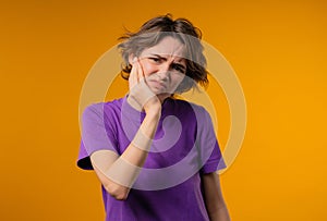 Young pretty woman with tooth pain, yellow background. Toothache, dental problem photo