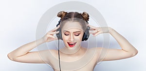 Young pretty woman trendy makeup bright red lips bun hairstyle bare shoulders act the ape with big dj headphones on white studio b