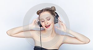 Young pretty woman trendy makeup bright red lips bun hairstyle bare shoulders act the ape with big dj headphones on white studio b