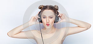 Young pretty woman trendy makeup bright red lips bun hairstyle bare shoulders act the ape with big dj headphones on white studio b