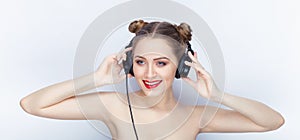 Young pretty woman trendy makeup bright red lips bun hairstyle bare shoulders act the ape with big dj headphones on white studio b