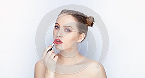 Young pretty woman trendy makeup bright red lips bun hairstyle bare shoulders act the ape with lipstick white studio background