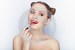 Young pretty woman trendy makeup bright red lips bun hairstyle bare shoulders act the ape with lipstick white studio background