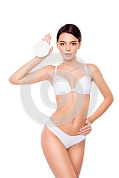 Young pretty woman in white underwear holding peeling sponge