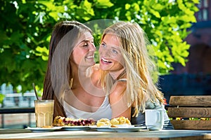 Young pretty women friends in street cafe