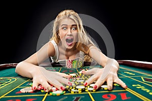 Young pretty women playing roulette wins at the casino