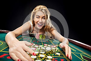 Young pretty women playing roulette wins at the casino