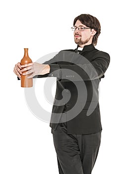 Young priest with bottle of alcohol isolated