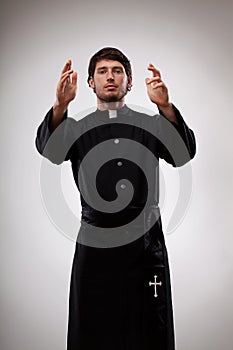 Young priest is gesturing to believers photo