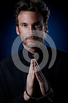 Young priest praying to God