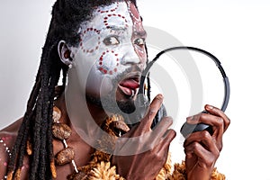 young primitive african native man tastes headphones, licks it