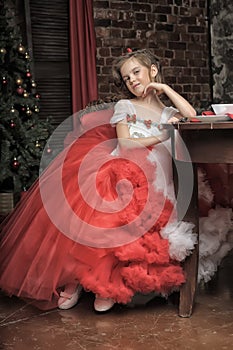 Young princess in a red and white dress sitting