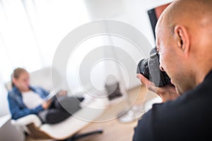 Young, pro male photographer in his studio during a photo shoot