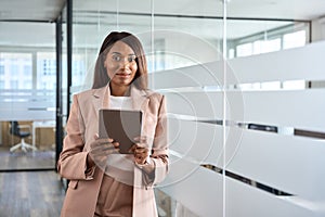 Young professional African American business woman holding tablet in office.