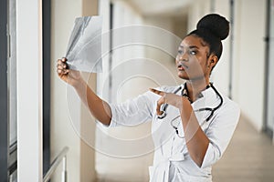 Young professional African-American doctor examining x-ray of patients chest