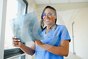 Young professional African-American doctor examining x-ray of patients chest