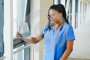 Young professional African-American doctor examining x-ray of patients chest