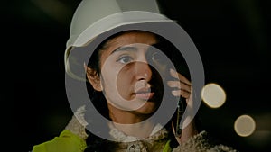 Young professional arabian woman technical engineer builder architect in uniform and hardhat talking mobile phone with