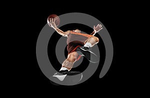 Young professional basketball player in action, motion isolated on black background, look from the bottom. Concept of