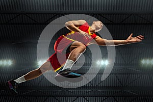 Young professional basketball player in action, motion isolated on black background, look from the bottom. Concept of